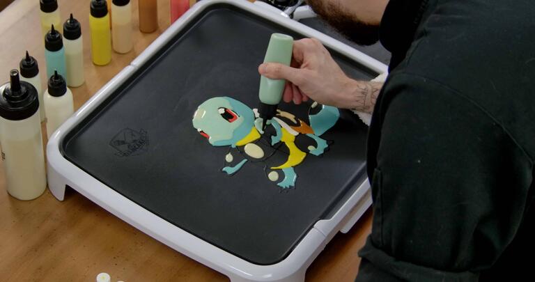Squirtle Pancake Art step 5.1: With your middle blue batter, you can start filling in the rest of Squirtle's head, arms, and tail. This is my favorite part of the process!