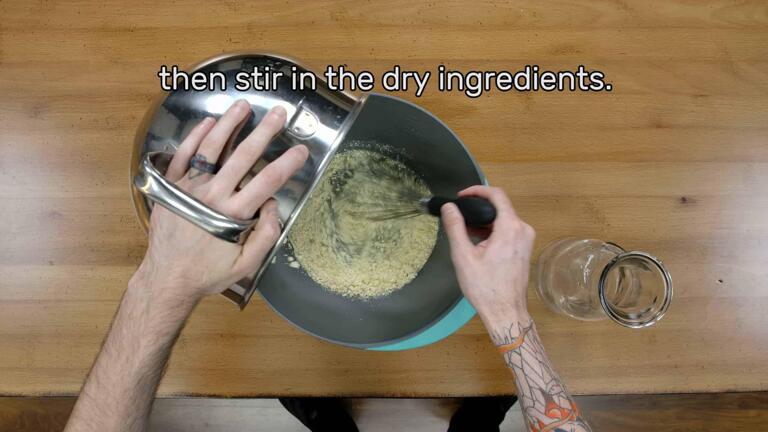 This image shows the dry powder being stirred into the water in a mixing bowl with a whisk, and says "then stir in the dry ingredients."