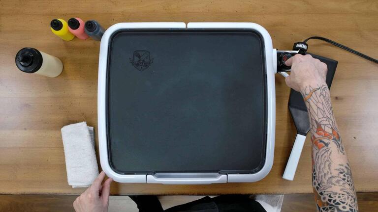 An image of the dancakes pancake art griddle, with the artist's hand pointing to the thermostate to indicate that the griddle is set to 'OFF'.